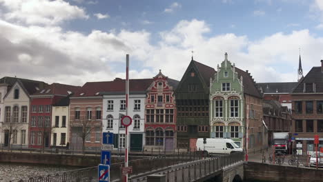 Time-Lapse-of-passing-clouds-over-three-historic-buildings-and-city-river