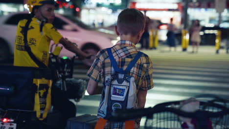 A-Young-Boy-Stands-on-the-Intersection-Facing-the-Traffic-Waiting-a-Green-Light-To-Cross-the-Road