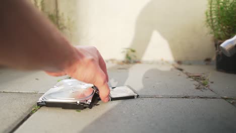 Slow-motion-clip-of-man-destroying-a-hard-drive-with-a-hammer