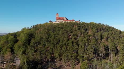 Vista-Aérea-Saliendo-Del-Bosque-Junto-Al-Medieval-Wachsenburg-En-Turingia,-Alemania