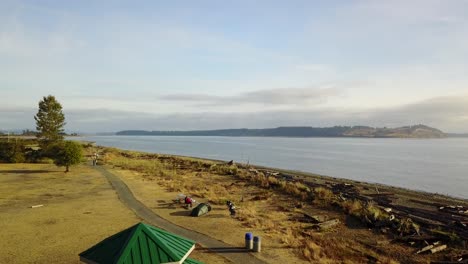 Aerial-flight-over-people-enjoying-a-coastal-path-on-vancouver-island,-Canada