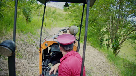 Shot-of-Swiss-Captain-driving-small-old-fashioned-train-up-the-hill-in-Costa-Rica