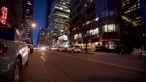 Cars-driving-downtown-in-a-modern-city-at-night