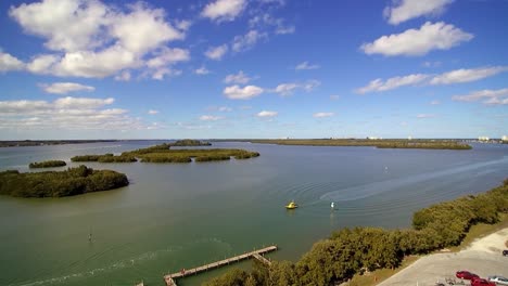 Vista-Aérea-De-La-Calzada-Norte-De-A1a-En-Ft-Pierce-Florida,-Bote-De-Remolque-Amarillo-Que-Se-Desplaza-Hacia-El-Sur-Por-La-Vía-Fluvial-A-Baja-Velocidad