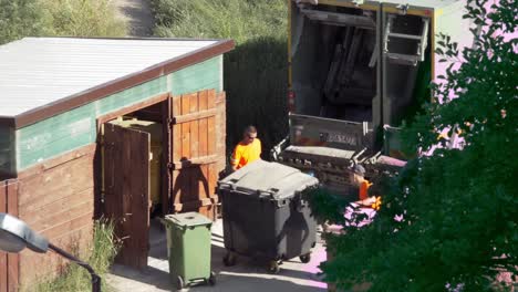 Hombre-Vacía-Botes-De-Basura-En-Un-Camión-De-Basura