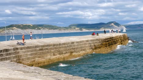 Ein-Junger-Mann-Springt-In-Lyme-Regis-Vom-Cobb-Ins-Meer