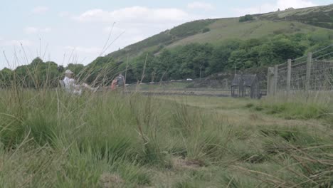 People-relaxing-in-scenic-Yorkshire-hills-landscape-wide-tilting-shot