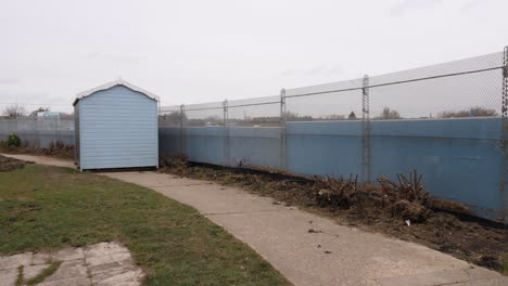 Beach-hut-lifted-off-its-footings-and-dumped-next-to-fence