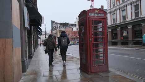 El-Tráfico-Pasa-Por-La-Icónica-Cabina-Telefónica-Roja-De-Londres-Bajo-La-Lluvia