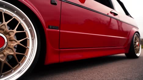 Gold-BBS-front-wheel-on-driving-VW-Volkswagen-Golf-MK1-car,-close-up