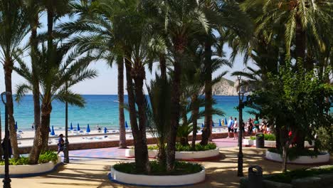 Locked-shot-of-Tourists-and-locals-walking-along-"Playa-de-poniente"-beach-with-protective-masks-during-coronavirus-pandemic