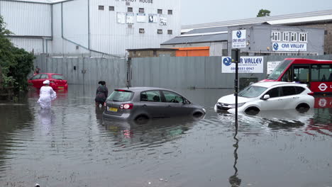 Zwei-Frauen-Wateten-Mit-überschwemmten-Autos-Und-Einem-Roten-Bus-Durch-Das-Hochwasser,-Nachdem-In-Der-Hauptstadt-Ein-Gewitter-In-Mehreren-Stunden-Heftige-Regenfälle-Im-Ausmaß-Von-Mehr-Als-Einem-Monat-Niedergegangen-War