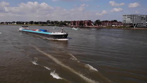 Aerial-View-Of-Speedboat-Going-Past-Acadia-Cargo-Ship-On-River-Noord