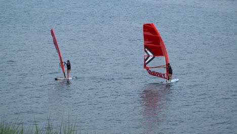 Dos-Mujeres-Practicando-Windsurf-En-El-Río-Han-Cerca-De-La-Orilla-Del-Río-Al-Atardecer