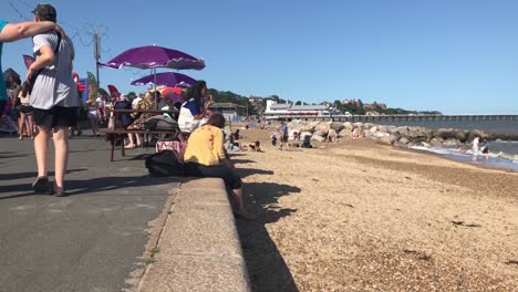 British-holiday-makers-enjoy-a-walk-along-the-sea-front-in-Felixstowe,-Suffolk,-UK