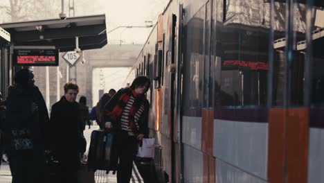 People-boarding-on-a-train-in-a-train-station,-Tordera,-Barcelona