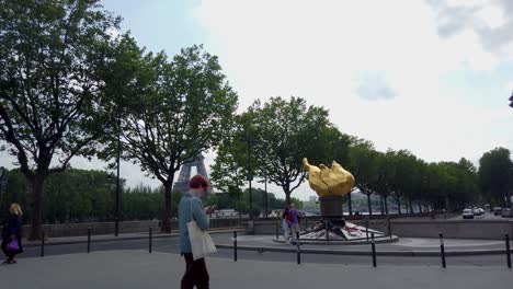 Toma-De-La-Torsh-De-La-Amistad-Francoamericana-Del-Monumento-A-La-Libertad-Cerca-Del-Pont-De-L&#39;alma-Donde-Murió-Lady-Diana-Con-Gente-Caminando-Y-La-Torre-Eiffel-Al-Fondo,-París-Francia