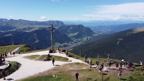 Seceda-En-Tirol-Del-Sur,-Alpes-Italianos,-Dolomitas,-Italia---Vista-Aérea-De-Drones-De-La-Estatua-De-Jesús,-Turistas-Y-Valle-De-Montaña