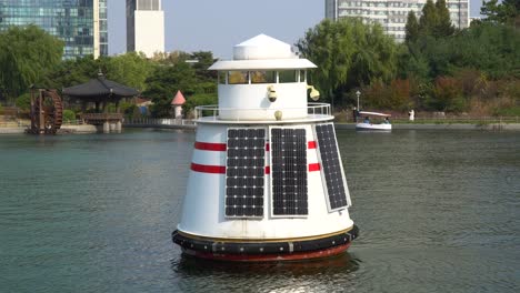 Boya-De-Medición-De-La-Calidad-Del-Agua-Del-Océano-Con-Paneles-Solares-En-Un-Lago-En-El-Parque-Central-De-Songdo,-Incheon,-Corea-Del-Sur