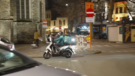 Deliveroo-Essenslieferant-Auf-Einem-Roller-Am-Abend-In-Gent,-Belgien