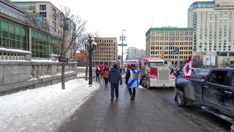 Crowds-of-people-walk-past-Freedom-convoy-truckers-protest-in-Ottawa,-Ontario,-Canada