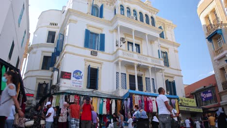 People-Walking-At-Place-de-la-Victoire-With-Exterior-View-Of-A-Restaurant-In-Tunis,-Tunisia