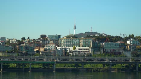 Yongsan-District-and-N-Seoul-Tower-on-Namsan-Mountain-by-Hangang-river-and-traffic-on-Gangbyeonbuk-ro-expressway-in-Autumn