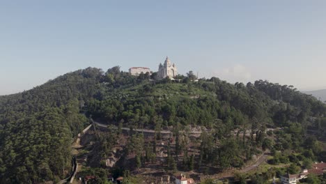 Antena-Dolly-Avanza-Hacia-La-Iglesia-De-Viana-Do-Castelo-En-Portugal-En-La-Cima-De-Una-Colina-Boscosa