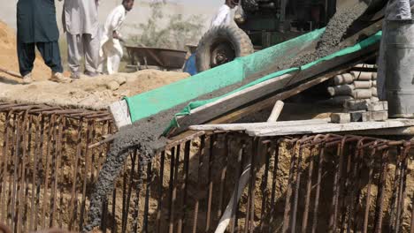 Wet-Concrete-Being-Poured-Down-Chute-At-Construction-Site-In-Karachi,-Pakistan