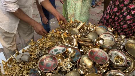 Un-Vendedor-De-Latón-Muestra-Estatuas-De-Latón-A-Los-Compradores-En-El-Mercado-De-Janpath-En-Nueva-Delhi