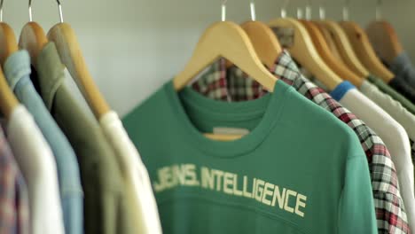 Close-up-shot-of-male-hand-taking-shirts-from-coat-rack-in-room-at-home