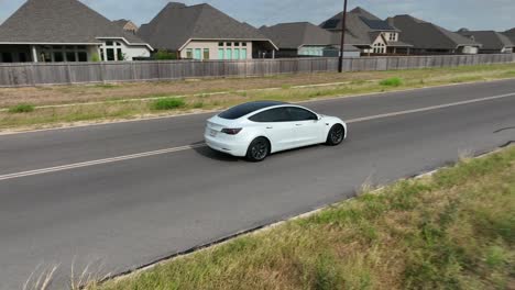 Front-windshield-view-of-Tesla-driving-in-USA-neighborhood