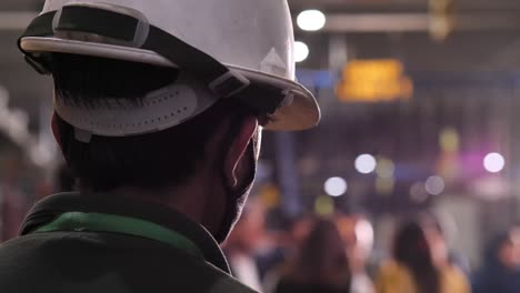 Close-Up-View-Behind-Male-Wearing-White-Hard-Hat-Looking-Forwards-With-Bokeh-Background