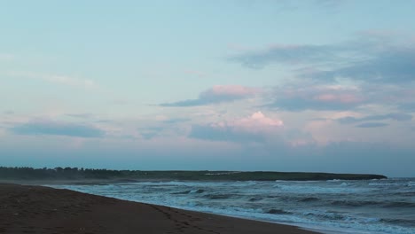 Nahaufnahme-Von-Meereswasserwellen,-Die-Am-Abend-Am-Sandstrand-Planschen