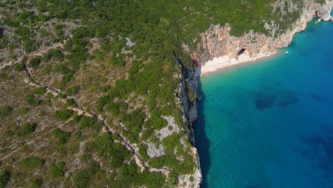 Drone-shot-of-the-Albanian-coast-in-the-Mediterranean-sea---drone-is-moving-away-dynamically-from-a-lonely-beach