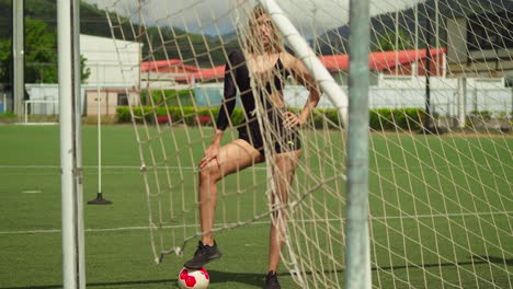 Young-latina-on-a-football-field-on-a-sunny-day-while-wearing-sports-wear