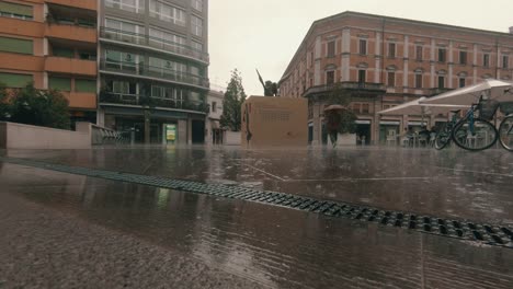 Static-shot-man-walking-on-the-streets-of-Venice,-a-big-cardboard-box,-in-middle-of-the-frame