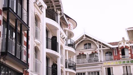 Buildings-at-the-town-square-with-round-terraces-and-ornate-murals,-Stable-handheld-shot