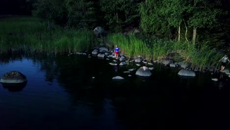 Niños-Aéreos-En-Aventura-Saltando-Sobre-Rocas,-Día-Soleado-De-Verano