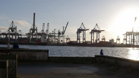 Timelapse-of-the-Hamburg-harbor-at-sundown-with-cranes-in-the-background