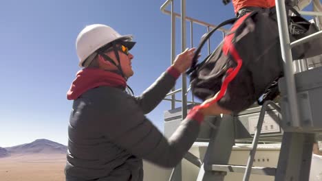 A-scientist-handling-and-carrying-gear-up-a-telescope-at-the-Alma-observatory