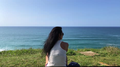 Woman-enjoying-a-sunny-day-on-the-coast-and-nice-views-of-the-sea-and-the-beach