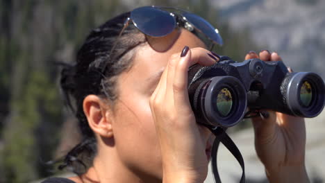 Chica-Guapa-Joven-De-4k-Mirando-La-Mitad-De-La-Cúpula-A-Través-De-Binoculares-En-El-Punto-Del-Glaciar-En-El-Parque-Nacional-De-Yosemite,-Caliofrnia