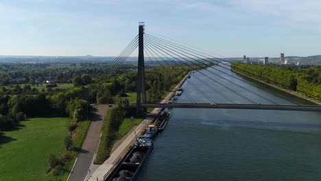 AERIAL:-Shot-of-a-suspension-bridge-over-a-canal-on-a-sunny-day