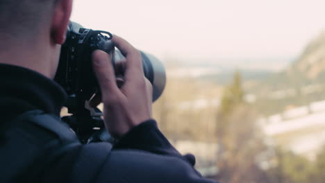 Professional-Photographer-sets-up-a-shot-and-then-turns-away-to-reveal-alp-mountains