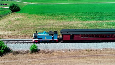 Thomas-the-Train-Steam-Locomotive-in-Amish-Countryside-on-a-Sunny-Summer-Day-as-seen-by-a-Drone