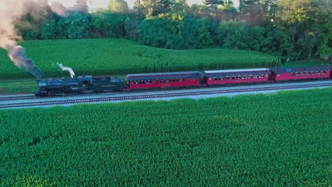 Steam-Train-at-Picnic-Area,-Pulling-out-of-Picnic-Area,-in-Amish-Countryside-as-seen-by-Drone