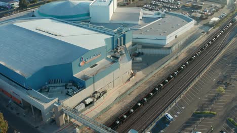 Aerial-Time-Lapse,-freight-train-passing-Rabobank-Arena,-Bakersfield,-California