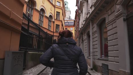 Woman-walking-through-a-narrow-street-in-Stockholm