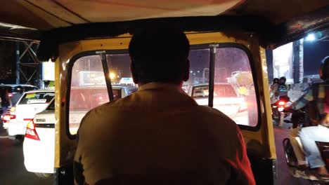 Vista-Panorámica-Desde-El-Interior-De-Un-Autorickshaw-Conduciendo-A-Través-Del-Tráfico-Durante-La-Noche